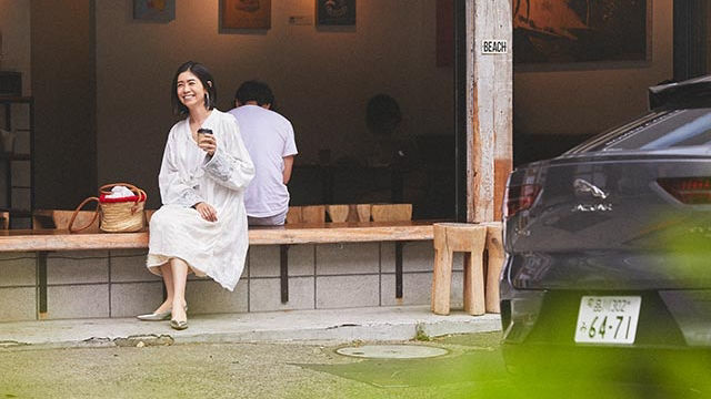 A girl in white dress sitting on a bench