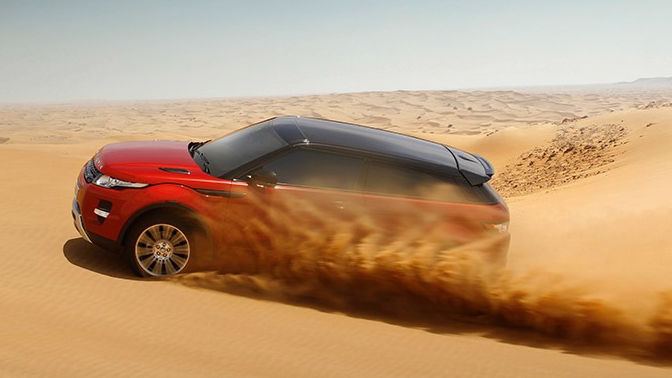 Range Rover Evoque driving through desert sand