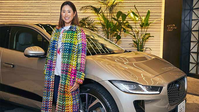 woman posing in-front of golden JAGUAR