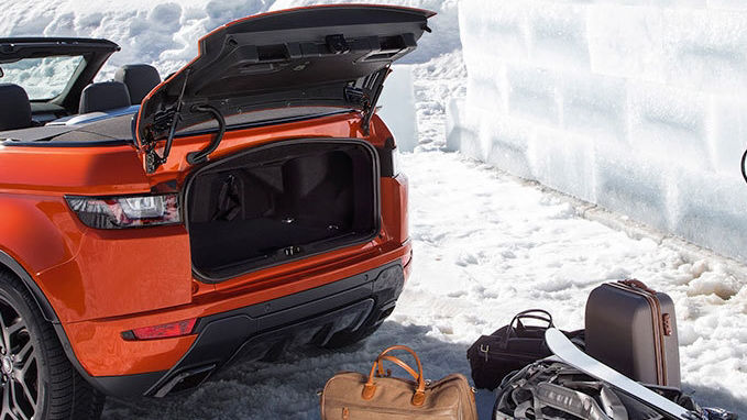 Red Range Rover with boot open and luggage outside car