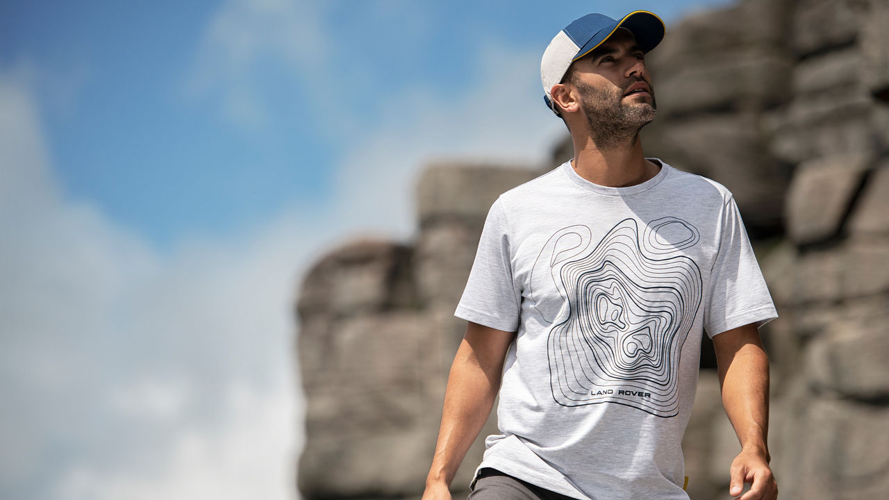 Male model on rocks looking to side wearing mens map t-shirt