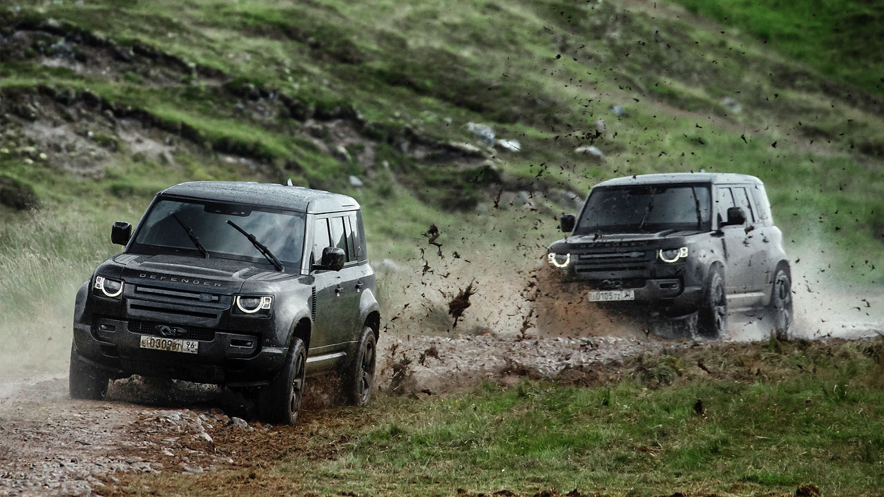 Two Defender Crossing on Forest Mud Road