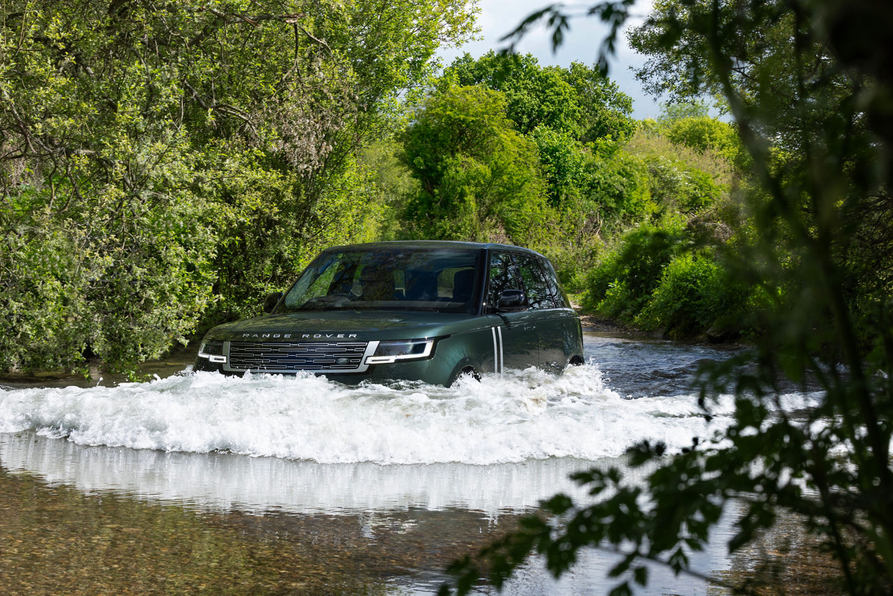 Range Rover fording forest stream