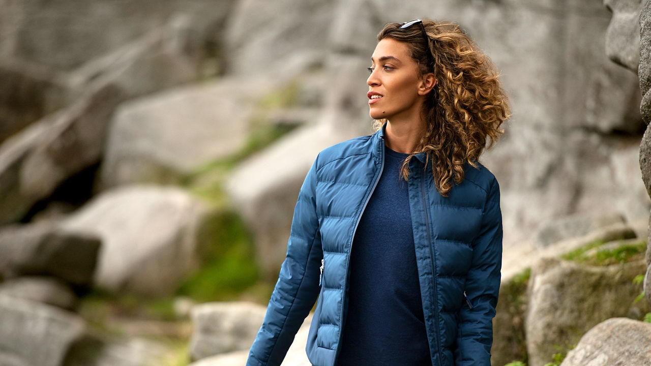 Female model on rocks looking to side wearing Quilted jacket
