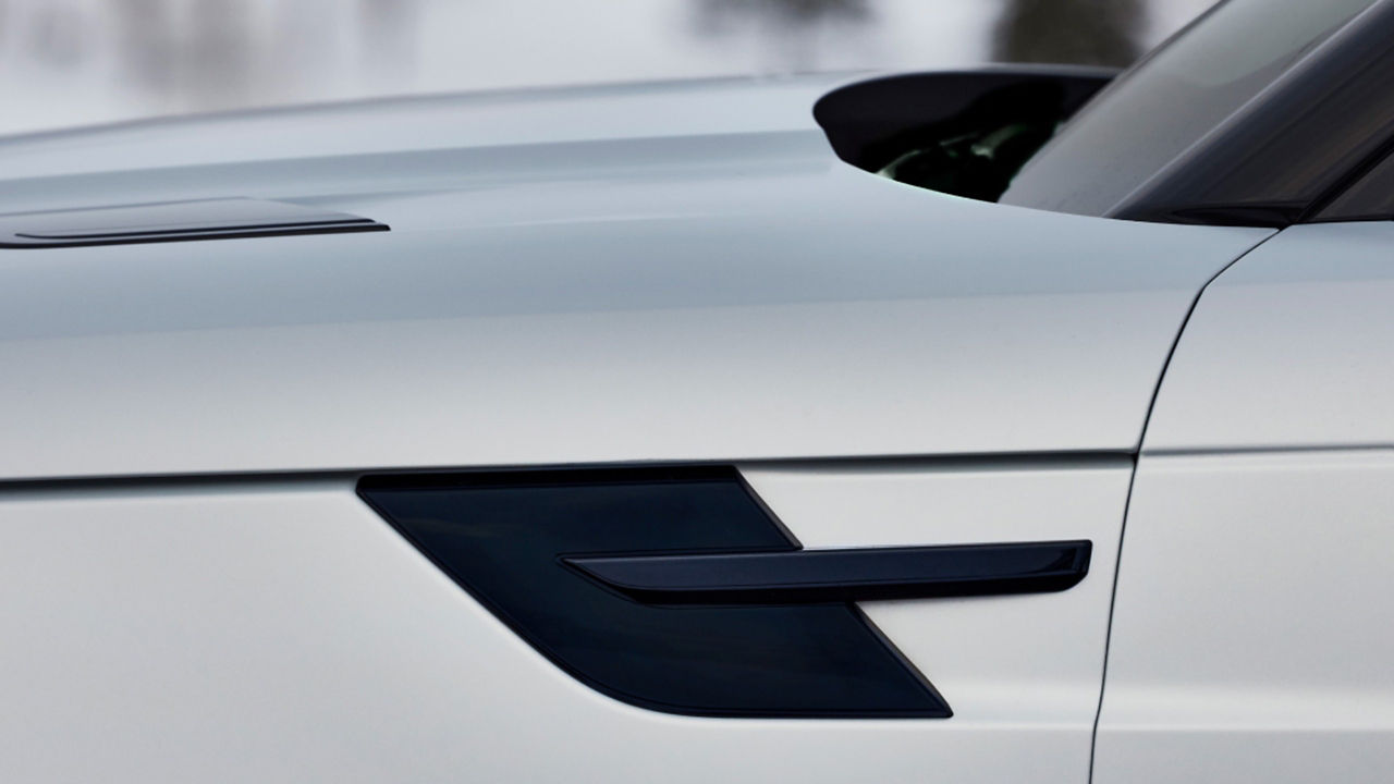  A close-up of the side door handles on a white Range Rover vehicle.