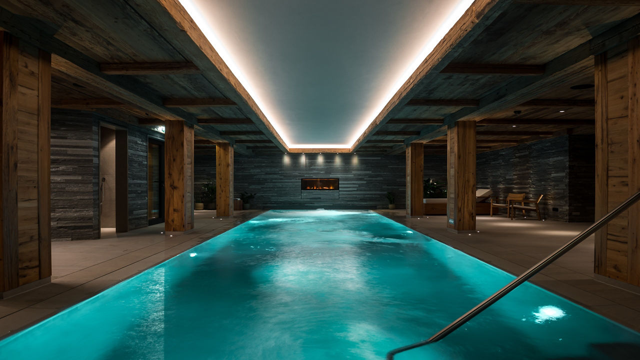 Indoor pool, featuring serene water and dim lights for relaxation and leisure.