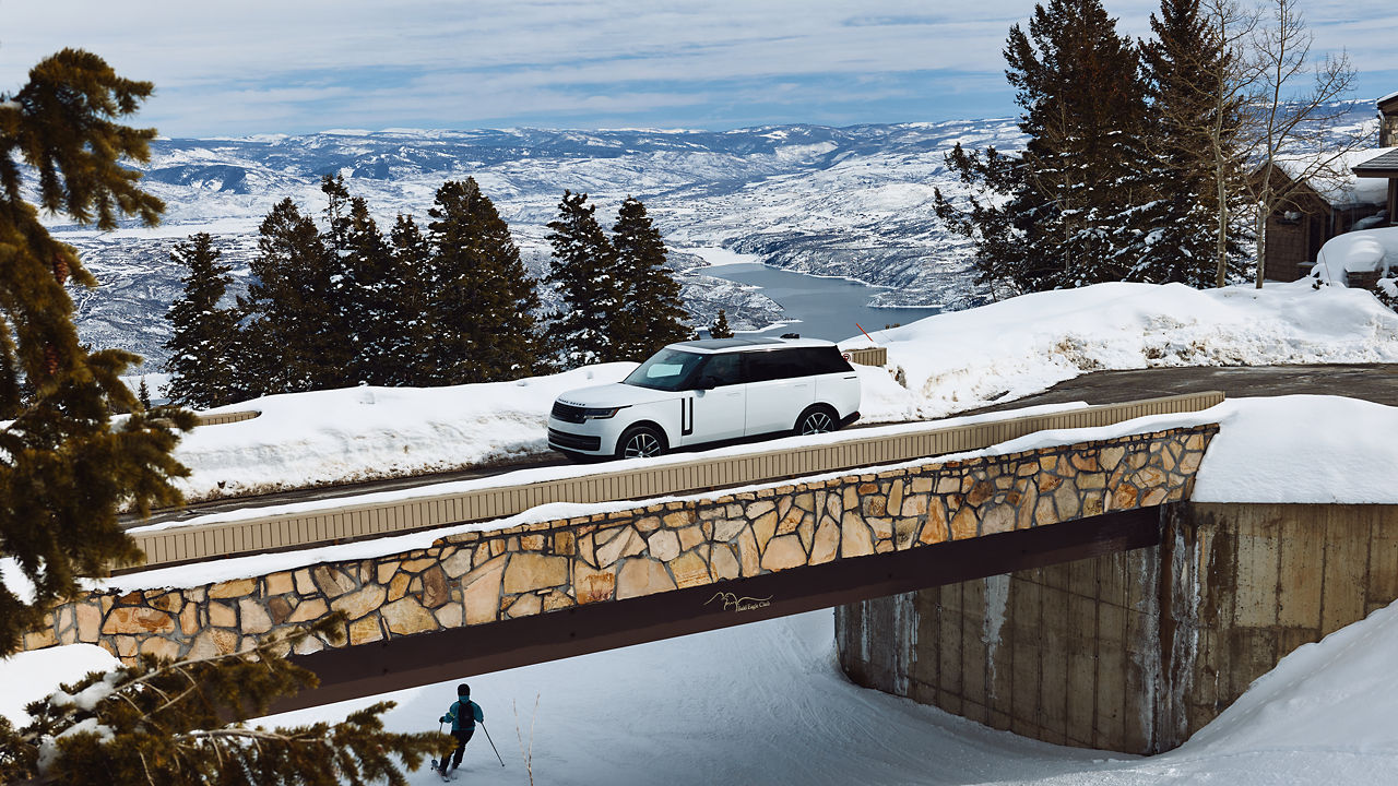 Range rover crossing bridge in snow