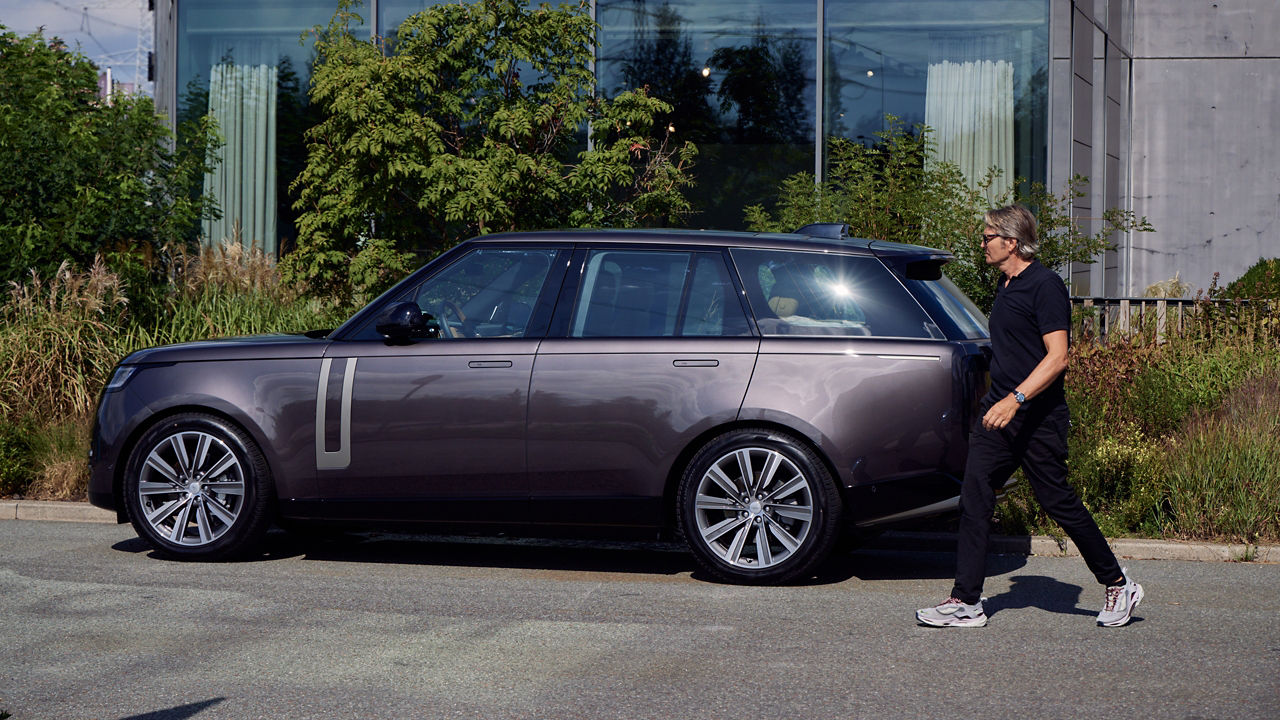 Side view of man and parked Range Rover 