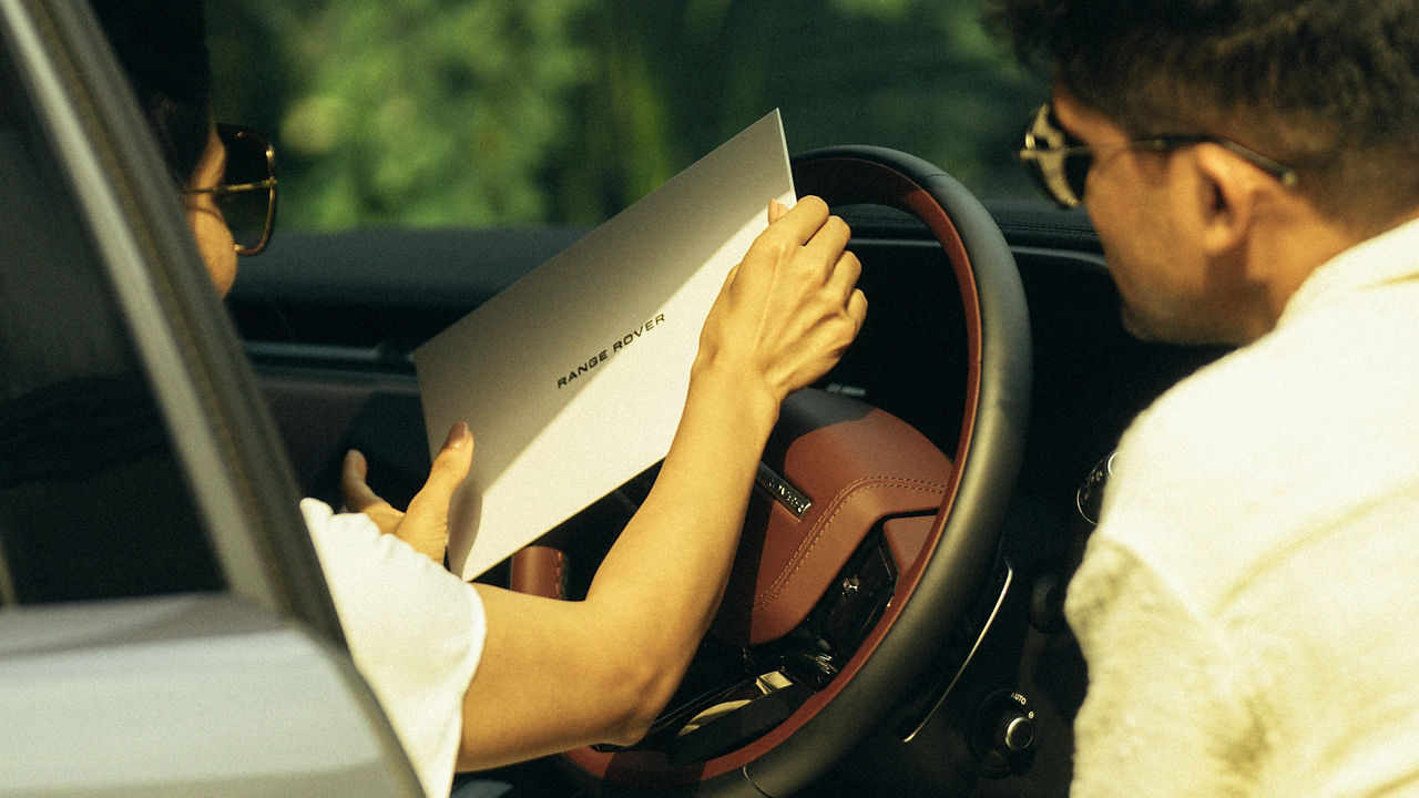 Lady showing Range Rover Event invite to a man