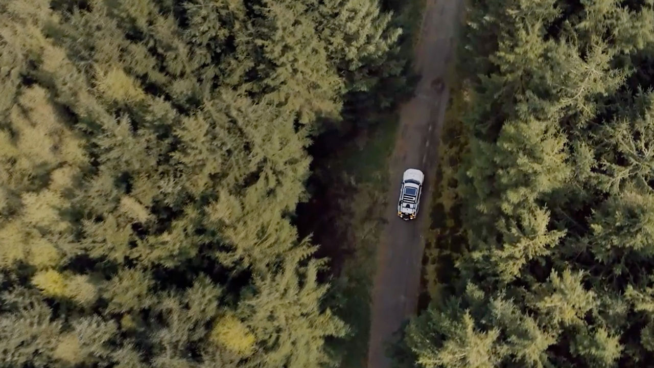 Aerial view of British Red Cross Defender driving on open road