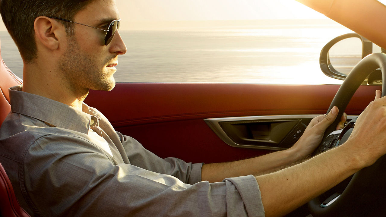 A close view of a man driving jaguar F-Type