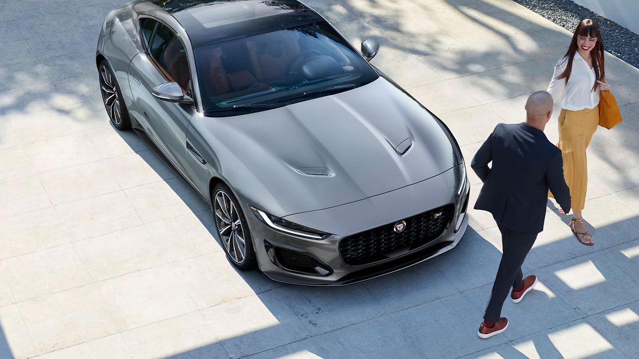 Jaguar F-Type parked and man and women walking from car