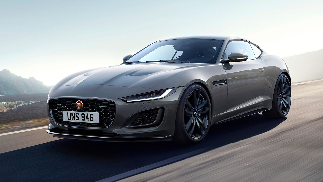 Jaguar F-TYPE running on the road surrounded with mountain at background 