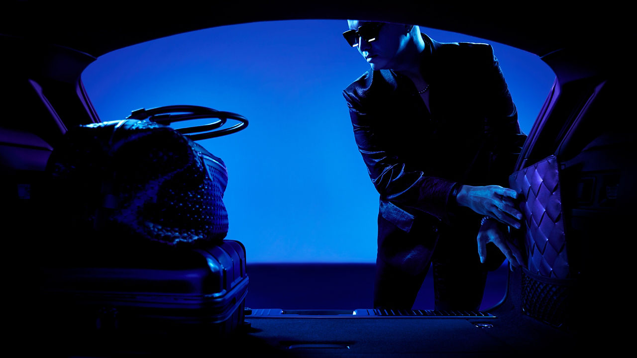 Man loading luggage in the Jaguar XF