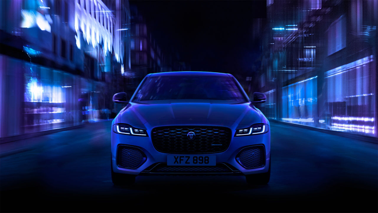The front angle of a Jaguar XF as it drives through a city