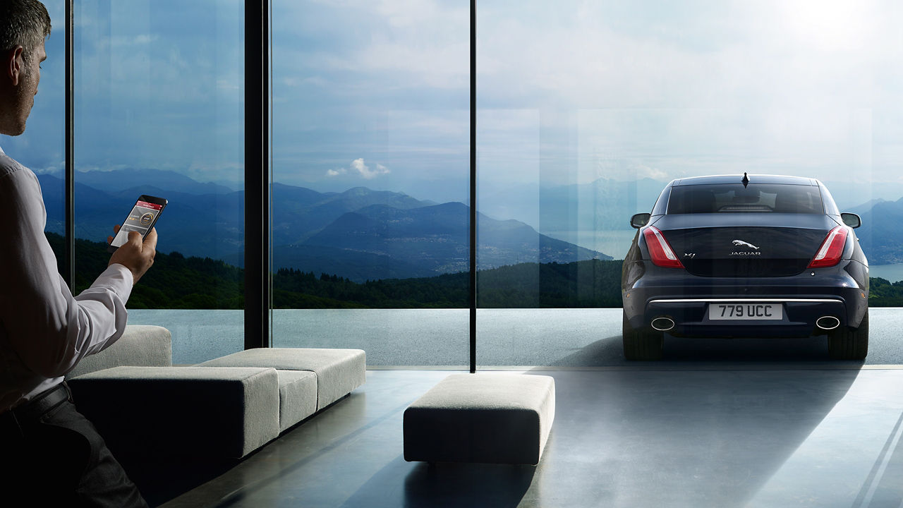 Jaguar XJ parked in front of the house and controlled with a mobile app