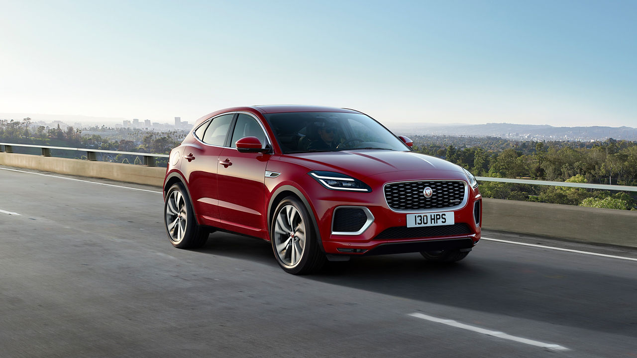 Parked Jaguar car on asphalt road with hill background