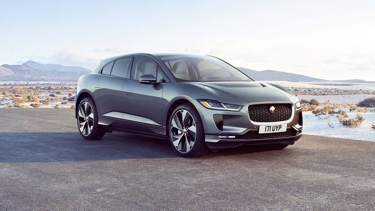 Jaguar I-PACE parked in river side road surrounded with mountains