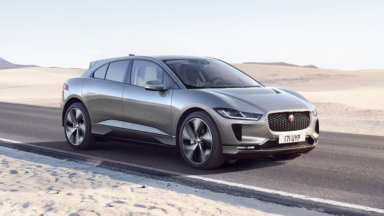Jaguar I-Pace running on the road with sand background 