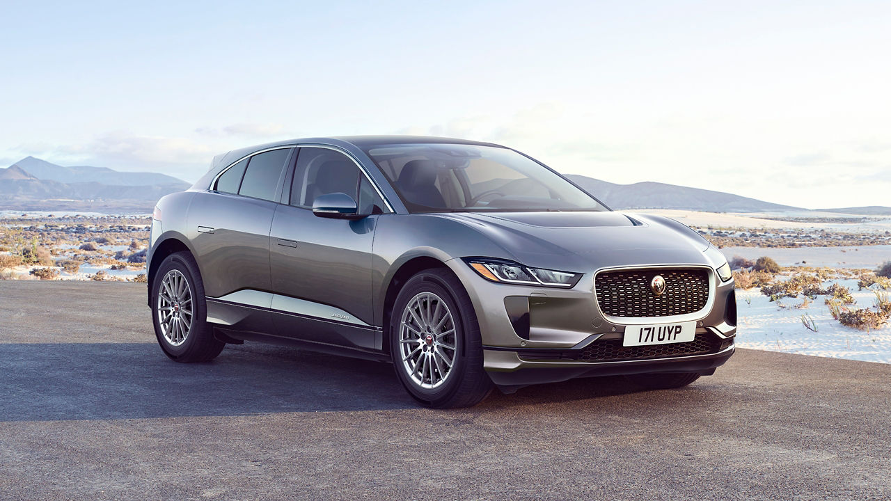 Jaguar I-PACE parked in river side road surrounded with mountains