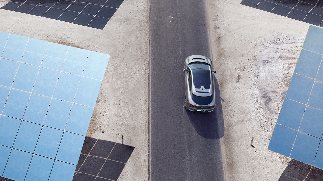 Jaguar I-PACE running on desert road surrounded with solar panel 