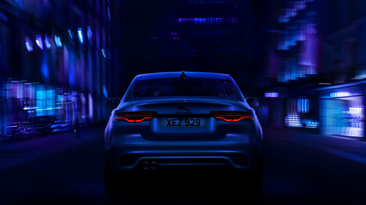 The rear angle of a Jaguar XE as it drives through a city
