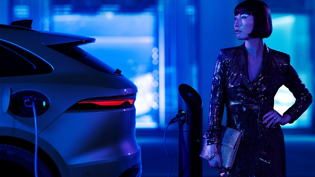 Unidentified beautiful young model standing beside Jaguar F-Pace car