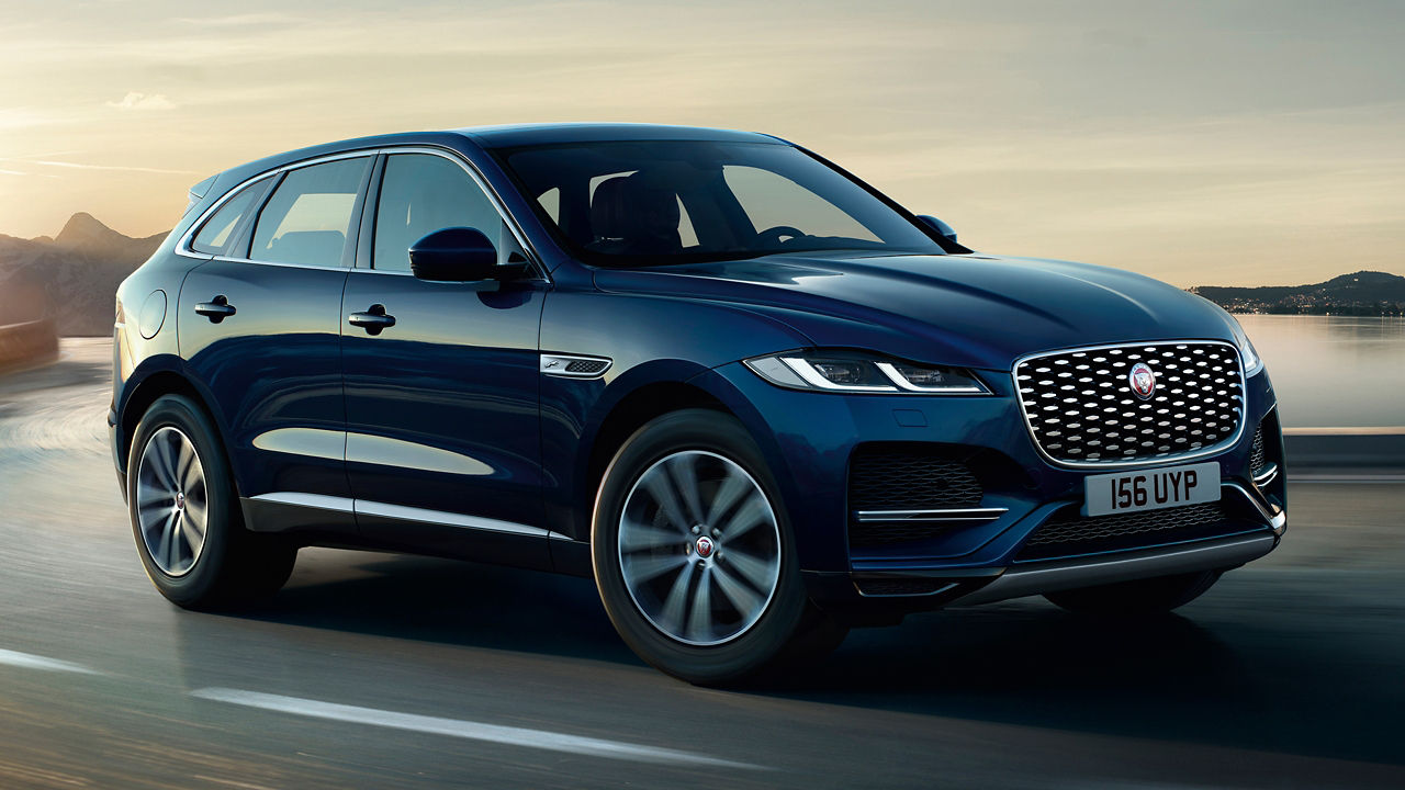 Jaguar F-PACE running on river side road surrounded with mountains