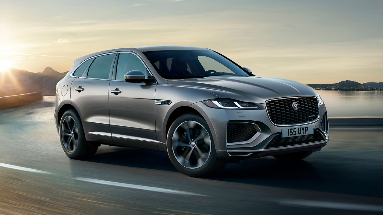 F-PACE running on river side road surrounded by mountains 