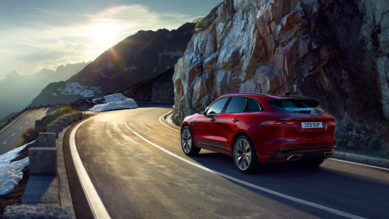 Jaguar F-PACE running on hill road in winter season 