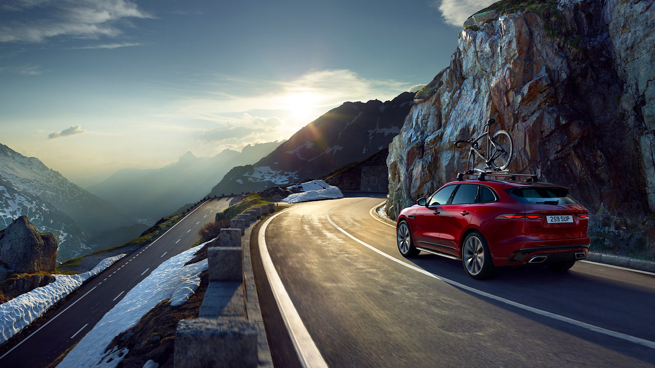 Jaguar F-PACE running on hill road in winter season 