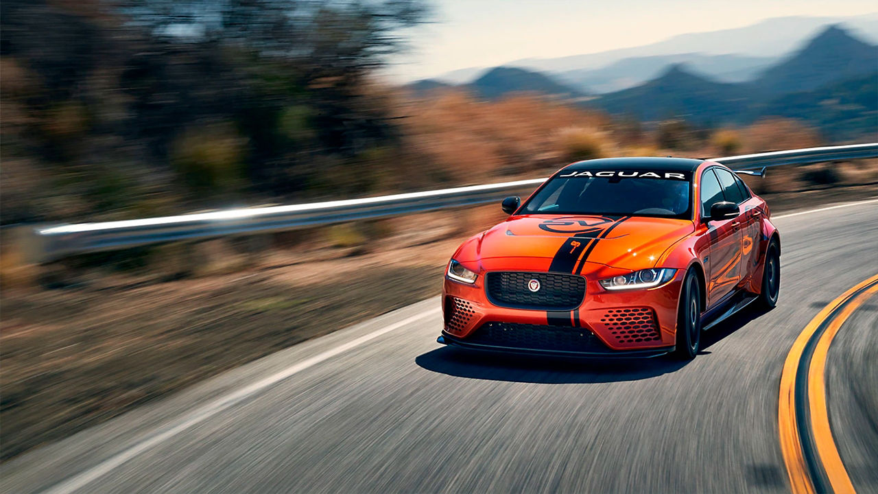 Jaguar XE Project 8 running on road surrounded by mountains