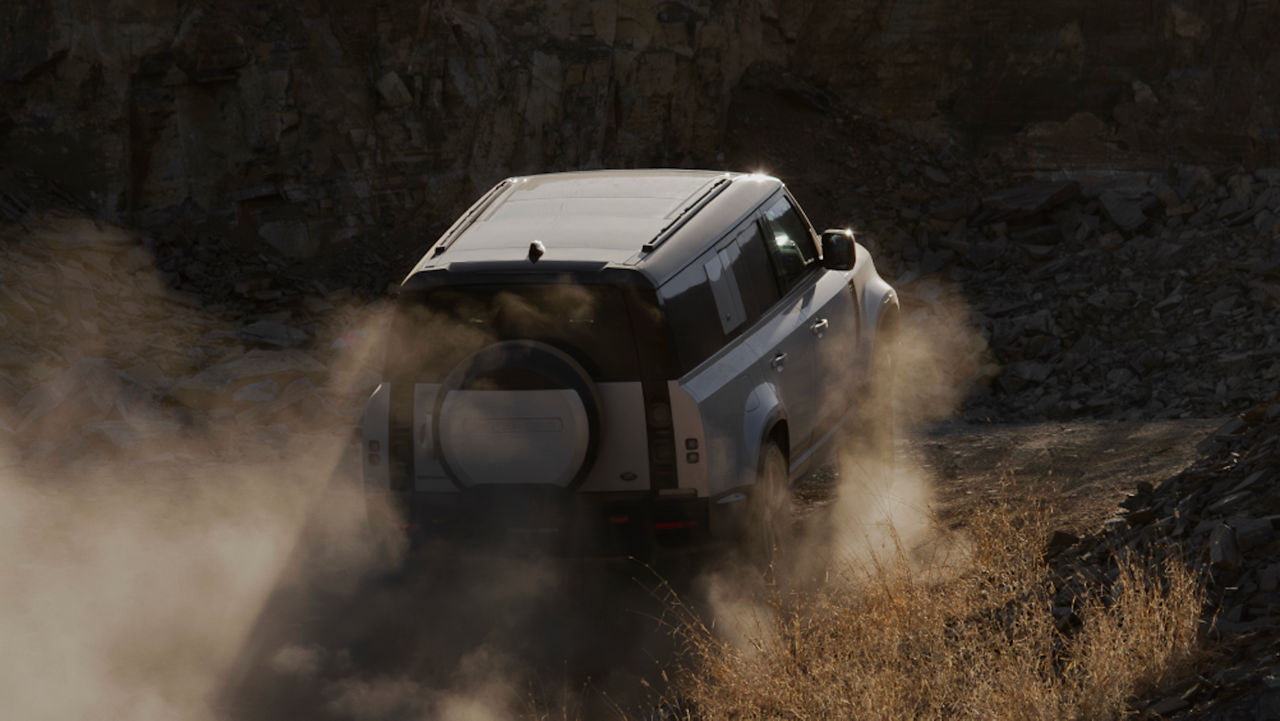 Defender driving on a rural track.