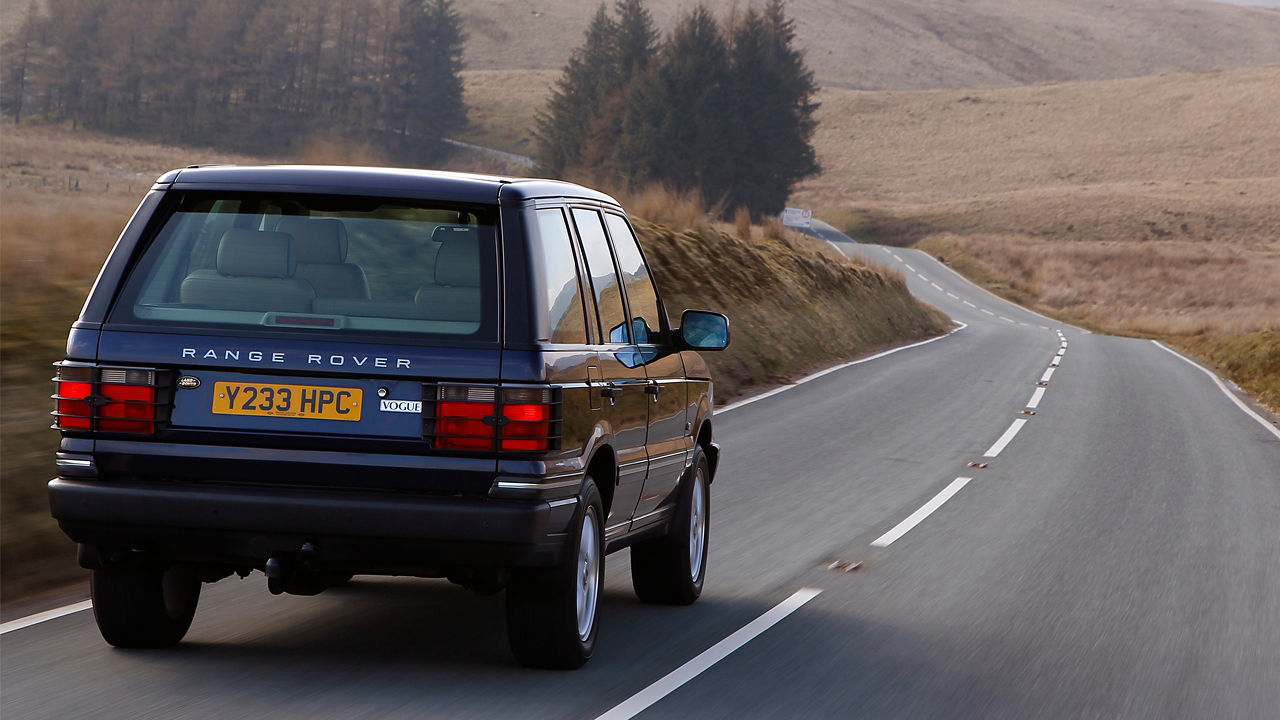 Older generation Range Rover driving through country roads