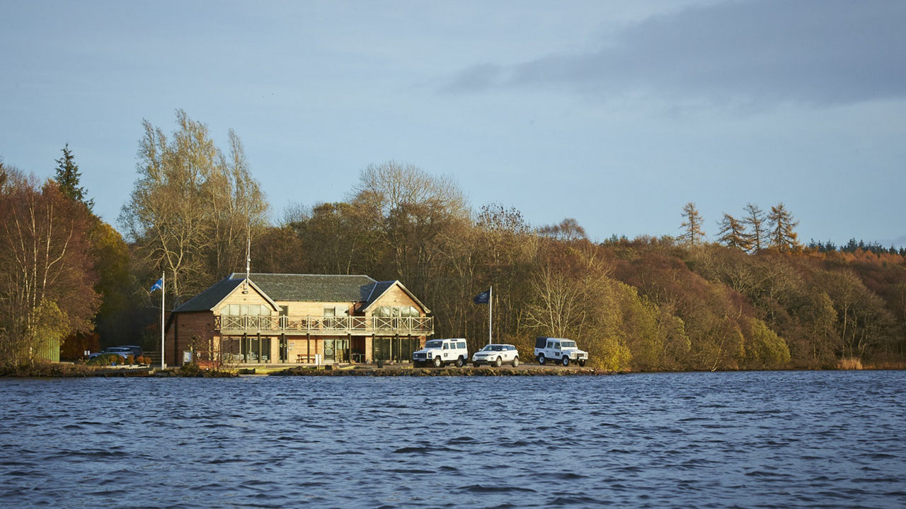 House near the water, Buildings surrounded by green trees and Parked Vehicle