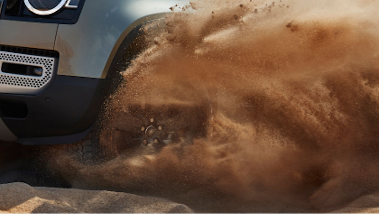 Detail view of the Defender wheel driving on sand.